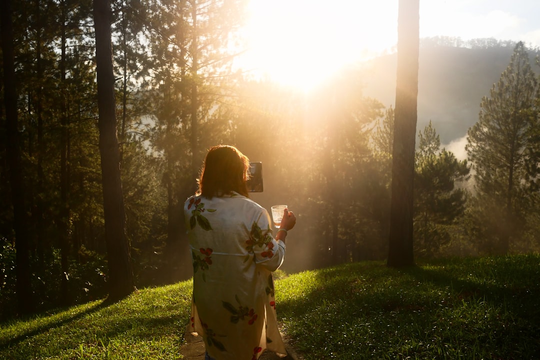 A teenager writing in a journal in warm sunlight.