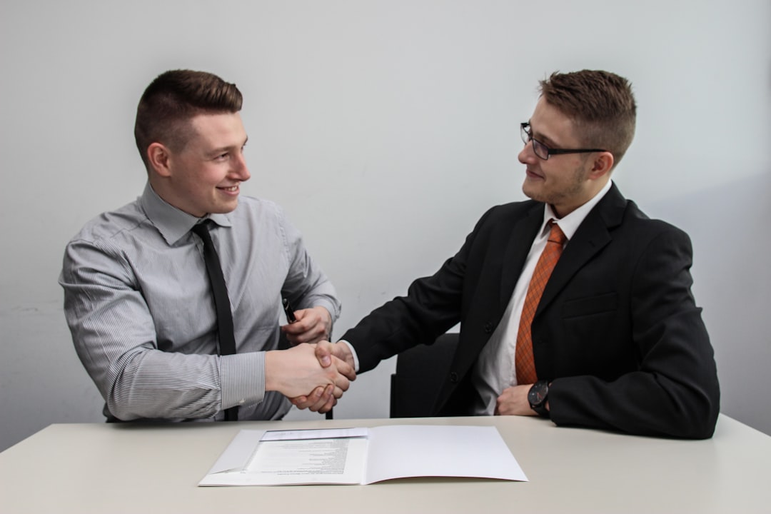 Young professional in a job interview setting with a handshake.