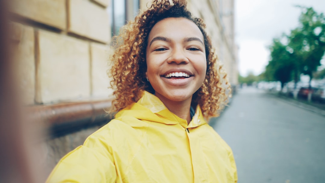 Confident young woman smiling outdoors in natural light.